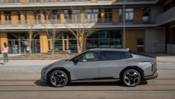 Kia EV4 Fastback fahrend vor Schule fotografiert