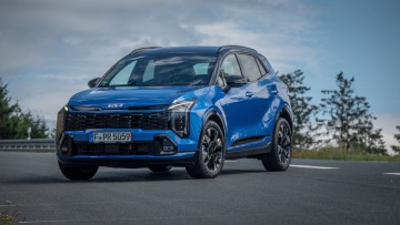 Kia Sportage in Blue Flame Metallic schräg von vorn gegen den Himmel fotografiert
