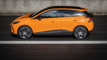 MG4 Extended Range in orange lackiert in der Seitenansicht, fotografiert auf Parkplatz