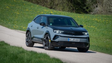 Opel Mokka GSE steht auf einem einsamen Teerstreifen und wurde von vorn fotografiert.
