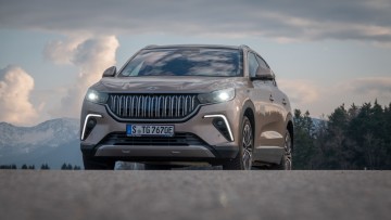 Togg T10X steht auf einer Anhöhe und wurde mit Wolken im Hintergrund von vorn fotografiert