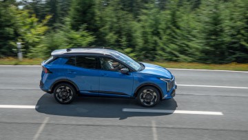 Mitzieher auf Straße vor Tannenbäumen auf dem Feldberg im Taunus vom KJia Sportage Facelift 2026