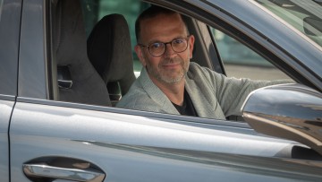 Christian M. Voß im Cupra sitzend durch das geöffnete Fenster nach draußen schauend