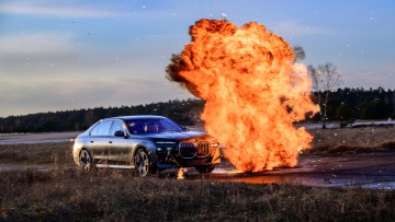 Gepanzerter BMW 760i fahrend durch Feuer
