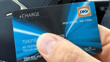 DKV-Ladekarte in der Hand vor einem Lenkrad gehalten