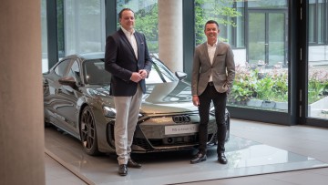 Stefan Quary und Carsten Kortüm vor Audi e-tron GT in der Audi-zentrale in Ingolstadt