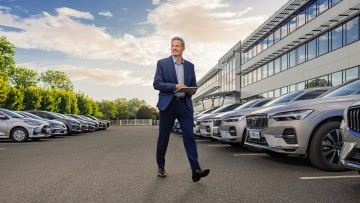Flottenmanager mit Tablet geht durch Fuhrpark