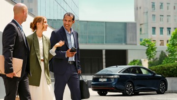 Kollegen unterhalten sich auf dem Firmenparkplatz