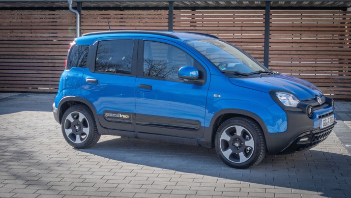 Fiat Pandina Fiat Pandina in blau lackiert schräg von vor fotografiert vor Holzwand