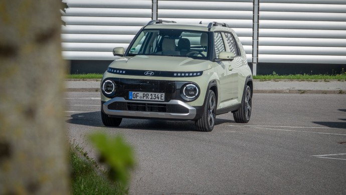 Hyundai Inster Prime (49 kWh) Hyundai Inster schräg von vorn vor Stahlwand fotografiert