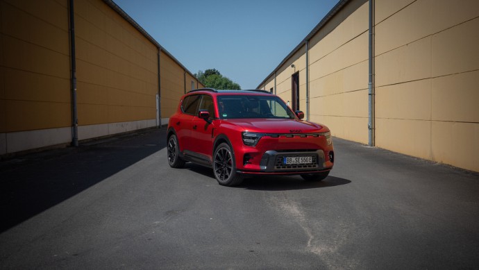 Rot lackierter Smart #5 Brabus zwischen zwei Hallen mit gelben Wänden