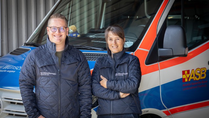 Stefanie Meyer und Luca Möhring stehen vor dem ASB-Wünschewagen