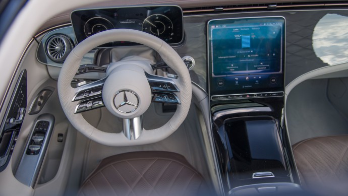 Mercedes EQE SUV Foto von außen durch das Panorama-Schiebedach aufgenommen. Lenkrad, Kombiinstrumnet und Zentraldisplay sind zu sehen