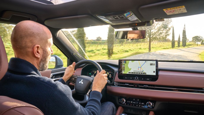 Fotoaufnahme vom Rücksitz während der Fahrt mit Gesamtansicht Cockpit und Fahrer