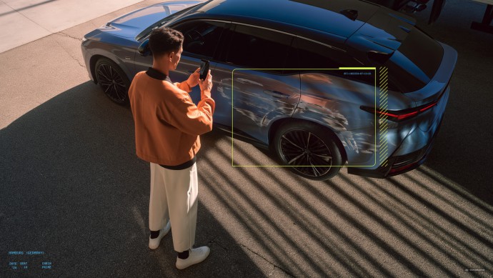 Junger Mann scannt Fahrzeug mit Smartphone