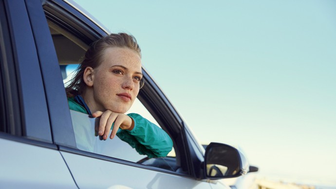 Frau blickt aus Seitenfenster eines Autos