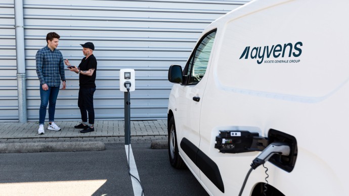 Elektrisches Nutzfahrzeug mit Ayvens Logo an Ladestation