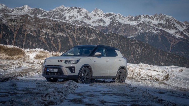 Weißer KGM Tivoli 4x4 steht auf einer Straße in der Abendsonne, von schräg vorn fotografiert