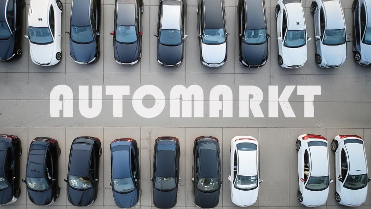 Autos stehen auf einem Parkplatz. Darauf ist der Schriftzug Automarkt zu sehen.