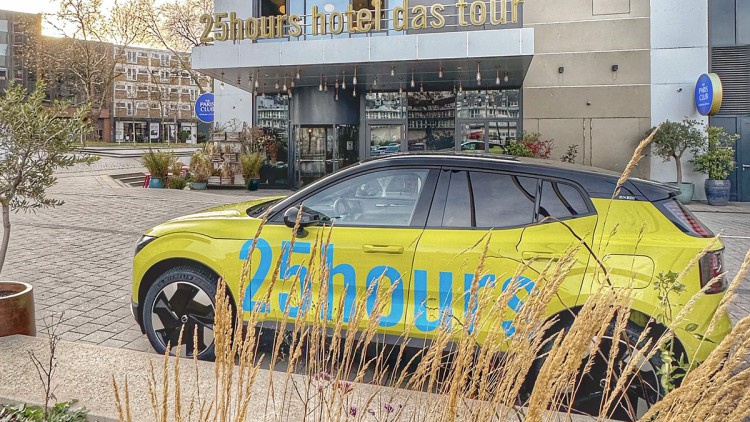 Ein Volvo EX30 steht vor dem 25hours Hotel Das Tour in Düsseldorf.