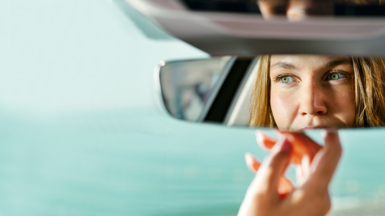 Frau blickt in Rückspiegel