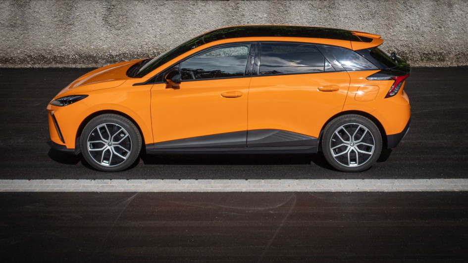 MG4 Extended Range in orange lackiert in der Seitenansicht, fotografiert auf Parkplatz