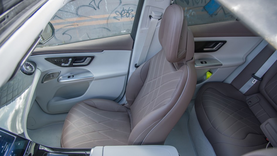 EQE SUV Beifahrersitz in braunem Leder, fotografiert von außen durch das Panorama-Schiebedach