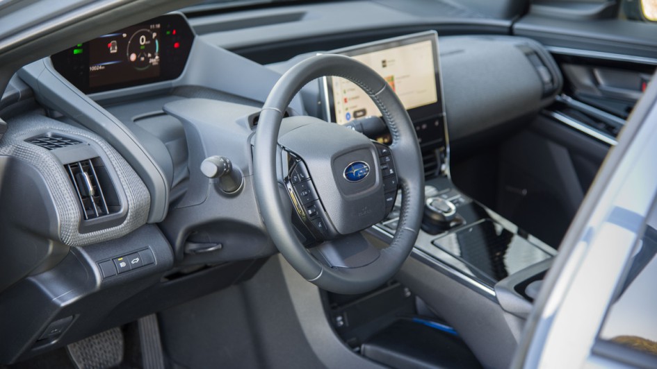 Subaru Solterra Foto durch die geöffnete Fahrertür auf Lenkrad und Cockpit
