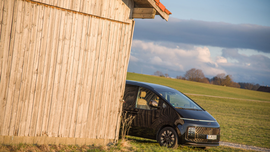Hyundai Staria vor Holzscheune Frontansicht von der Seite