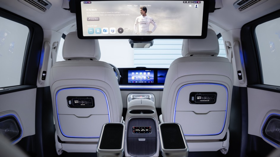 Foto von hinten auf die Rückseite der Vordersitze im Mercedes VLE mit ausgefahrenem Mega-Bildschirm, der aus der Dachverkleidung elektrisch angetrieben, herausfährt.