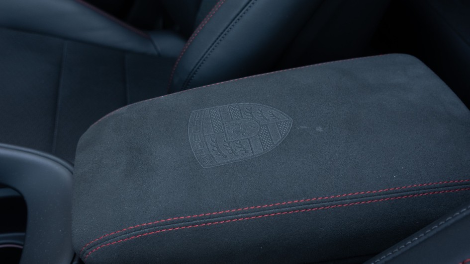 Porsche-Wappen auf der vorderen Mittelarmlehne, die mit Race-Tex bezogen ist