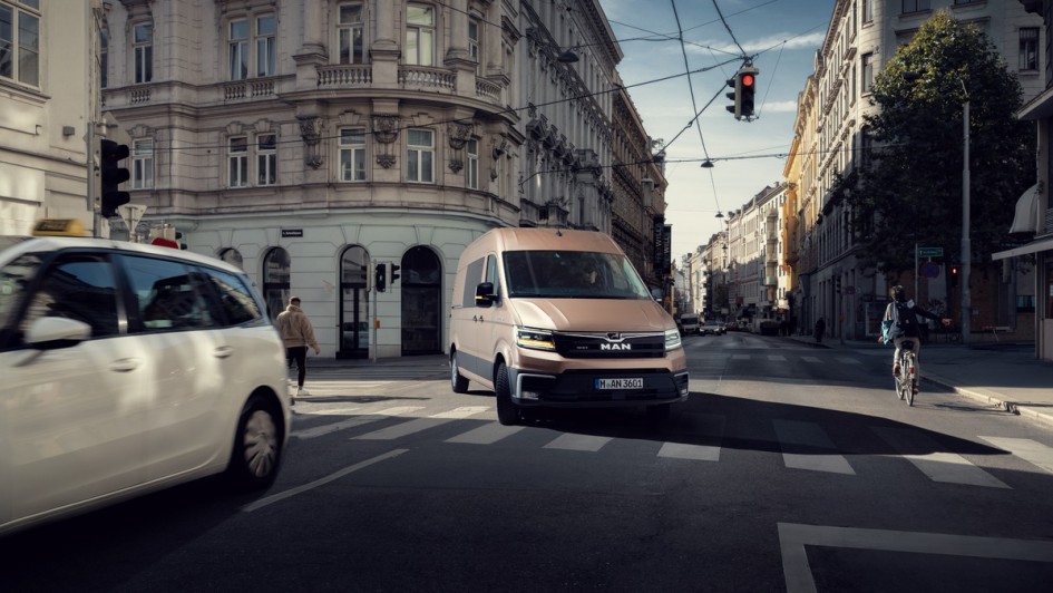 MAN TGE in gold fährt in der Stadt um die Kurve