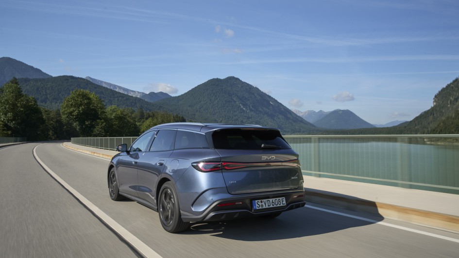 Von hinten fotografierter BYD Seal 6 DM-i Touring fahren auf einer Brücke in den Vorderalpen
