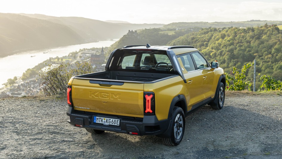 Schräg von hinten fotografierter KGM Musso EV, bei dem man auf die Pick-up-Ladefläche schauen kann