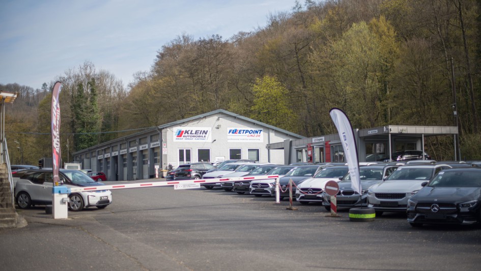 Ansicht des Klein Automobile Geländes mit Fahrzeugen im Vordergrund, gebaeude im Hintergrund