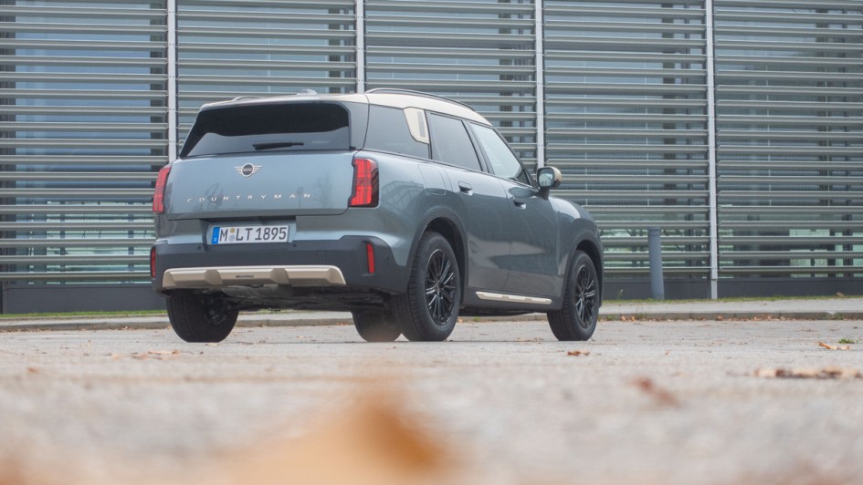 Mini Countryman Diesel stehend schräg von hinten aufgenommen, vor Glaswand.