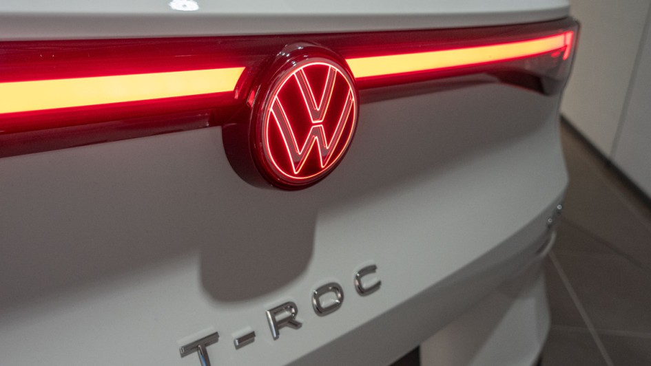 Beleuchtetes Logo am Heck des neuen VW T-Roc, der in weiß lackiert ist