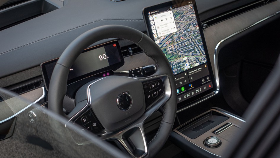 Foto durch das halb geöffnete Fahrerfenster auf das Lenkrad des Volvo EX90