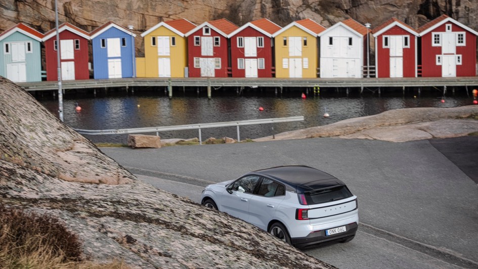 Volvo EX30 mit Schwedenhäusern im Hintergrund