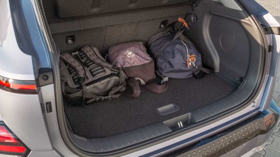 Foto mit geöffnetem Kofferraum des Hyundai Kona Elektro und darin liegenden Taschen