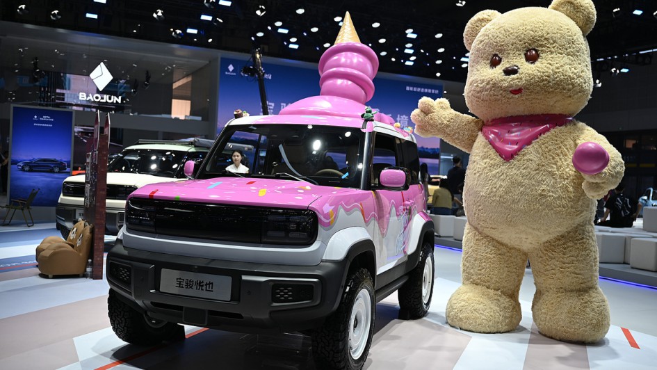 Ein Auto der chinesischen Marke Baojun steht mit einem Eishörnchen auf dem Dach auf einem Messestand