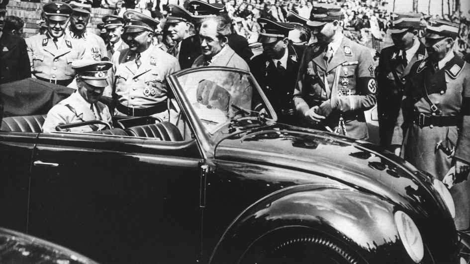 Adolf Hitler begutachtet auf der Rückbank sitzend den ersten Wagen vom Typ Käfer, der 1936 bei der «Gesellschaft zur Vorbereitung des deutschen Volkswagens» in Stuttgart nach den Entwürfen des Automobilkonstrukteurs Ferdinand Porsche (M, ohne Kopfbedeckun